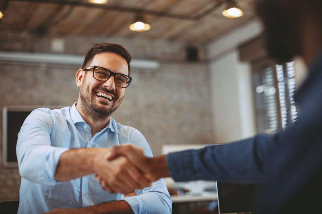 Frequently Asked Questions About Selling A Mortgage Note. Man shaking the hand of seller at closing.